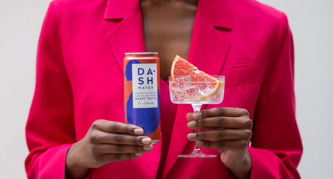 Girl in pink holding a DASH grapefruit cocktail