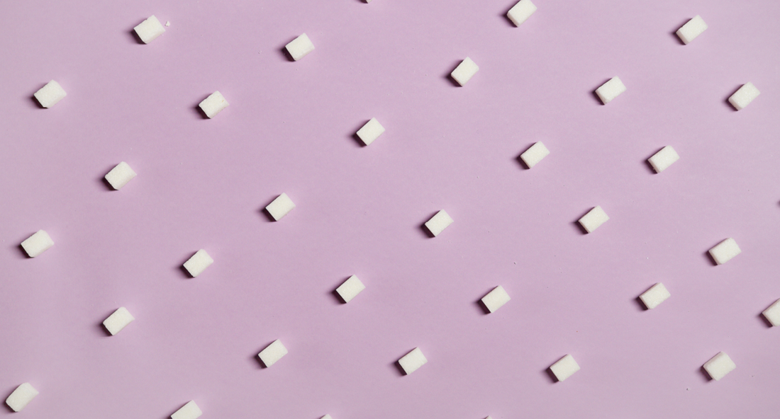 Sweetener and sugar cubes on a pink background